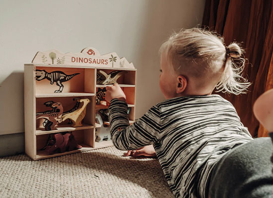 baby using wood toy shelf